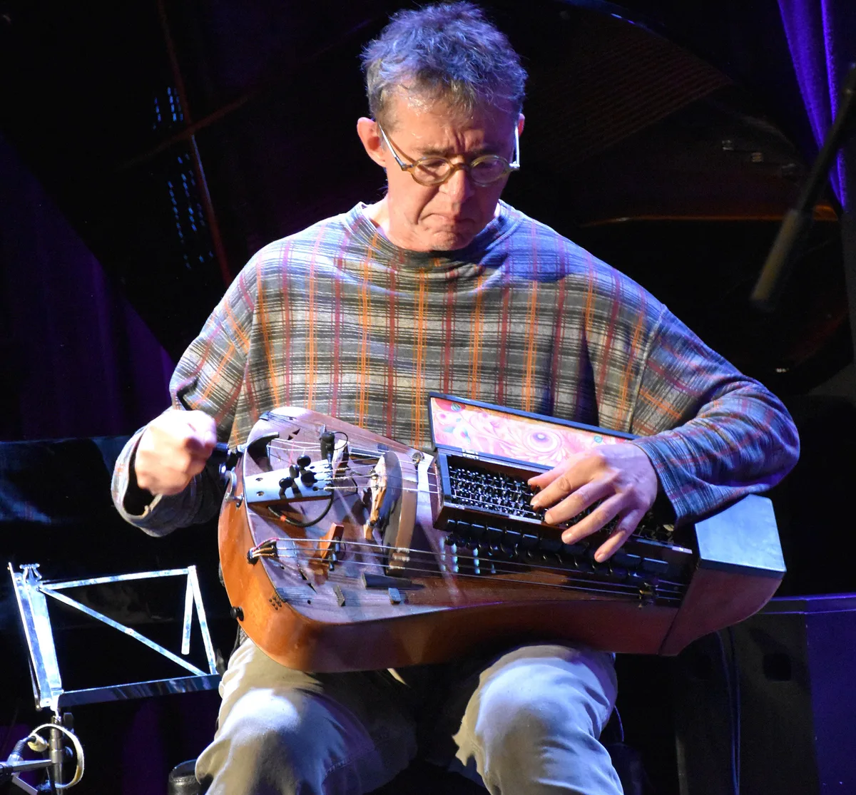 Ein Musiker mit einer Drehleier auf einer Bühne.